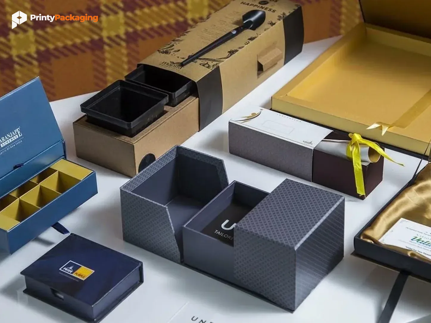 Assorted rigid and drawer gift boxes with inserts laid out for a packaging quote